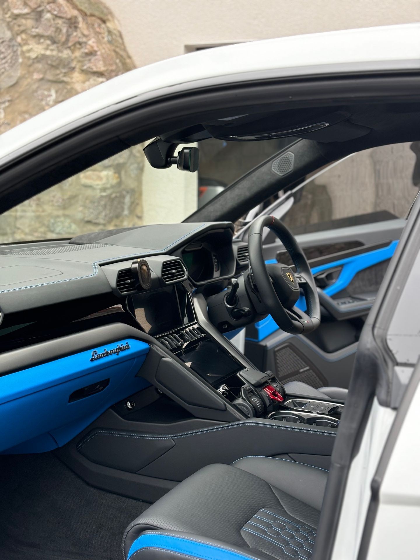 Interior view of a luxury car with black and blue leather seats and advanced dashboard features.